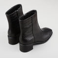 Load image into Gallery viewer, Le Sansa Spike Black boots with crocodile print and pointed toe, shown from the back view.