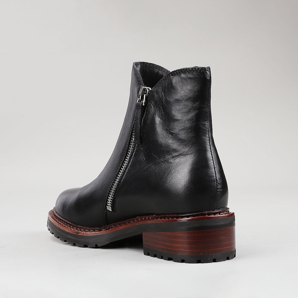 Black LE SANSA CAYLA boots by Le Sansa with sleek design and pointed toes, displayed on a neutral background.