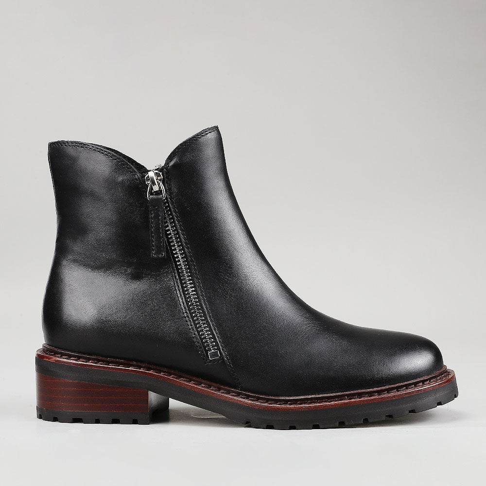 Black Le Sansa Cayla boots shown from the side, featuring sleek design and ankle-high style.