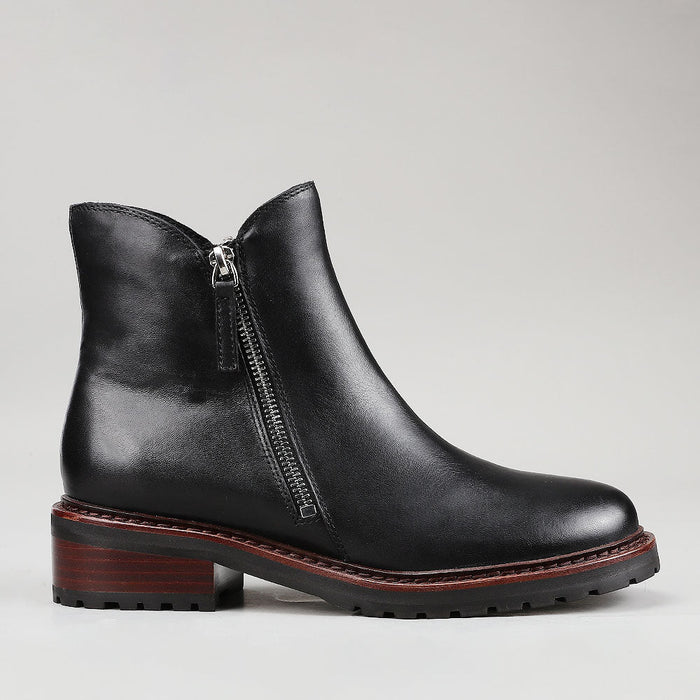 Black Le Sansa Cayla boots shown from the side, featuring sleek design and ankle-high style.