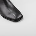 Load image into Gallery viewer, Close-up of black Le Sansa Sansa Spike boots featuring textured spike details and sleek leather finish.
