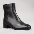 Load image into Gallery viewer, Le Sansa Spike Black boots with black leather and spike details, shown from the side with a crocodile print pattern.
